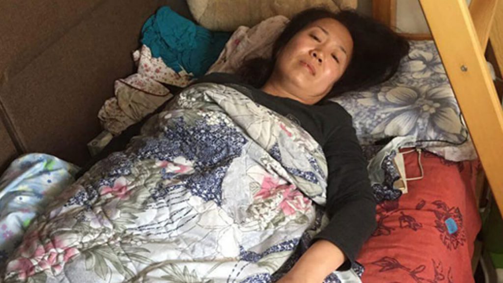 Beijing activist Li Meiqing rests in bed after suffering a caudal bone fracture from beatings by Chinese security officials as she and others tried to deliver food to Li Wenzu, wife of disappeared human rights lawyer Wang Quanzhang, April 12, 2018. Photo courtesy of an RFA listener.