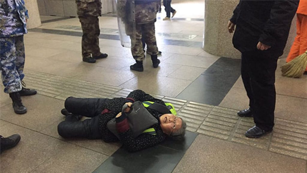 Pu Wenqing, the elderly mother of Chinese rights activist and website editor Huang Qi, after she was shoved to the ground by official 'interceptors' in Beijing, who detained her after she tried to appeal for Huang's release, Dec. 7, 2018.