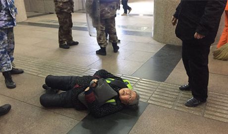 Pu Wenqing, the elderly mother of Chinese rights activist and website editor Huang Qi, after she was shoved to the ground by official 'interceptors' in Beijing, who detained her after she tried to appeal for Huang's release, Dec. 7, 2018.