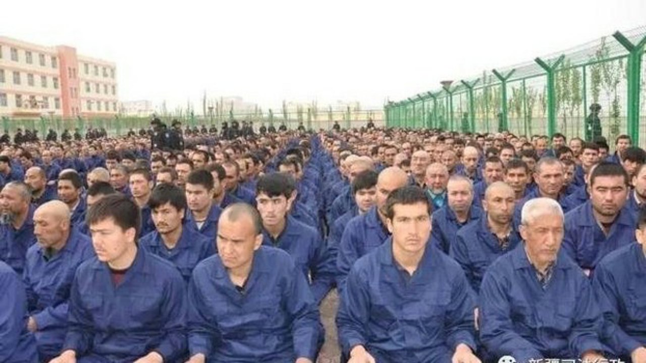 A photo posted to the WeChat account of the Xinjiang Judicial Administration shows Uyghur detainees listening to a speech at a re-education camp in Hotan prefecture's Lop county, April 2017. Wikipedia