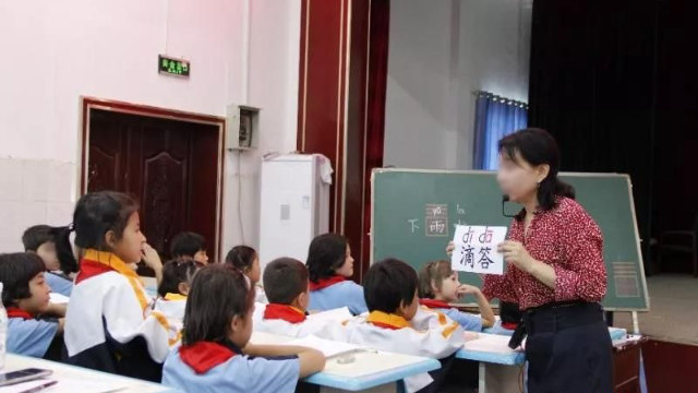 A teacher is teaching Chinese in a primary school in Xinjiang.