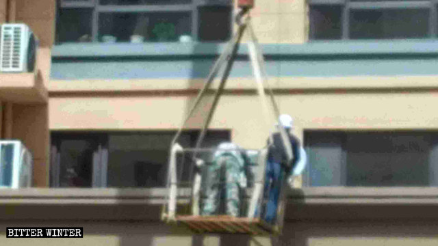 Workers dismantling satellite antennas