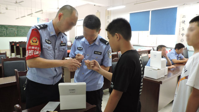 Public security bureau officers in Sichuan’s Shifang city collect middle school students’ DNA samples.