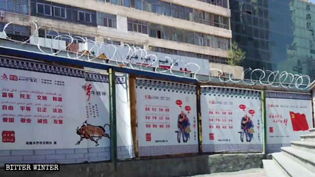 Propaganda posters promote President Xi Jinping’s Chinese dream on a wall with barbed wire.