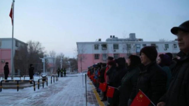 A residential community in Xinjiang organizes its residents for a flag-raising ceremony.