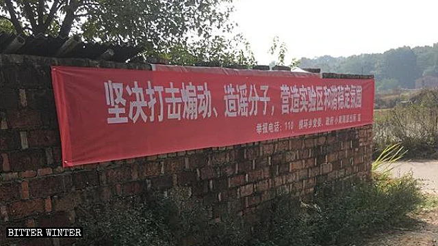A banner “Resolutely combat instigators and gossipers” was put up in one of the villages to intimidate its residents.