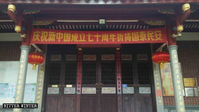 A banner hangs at the Longwo Temple entrance, celebrating the 70th anniversary of the founding of the new China.