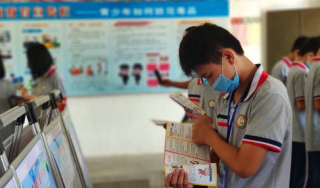 A student reads anti-xie jiao materials on a school campus in Guangdong’s Enping city in June.