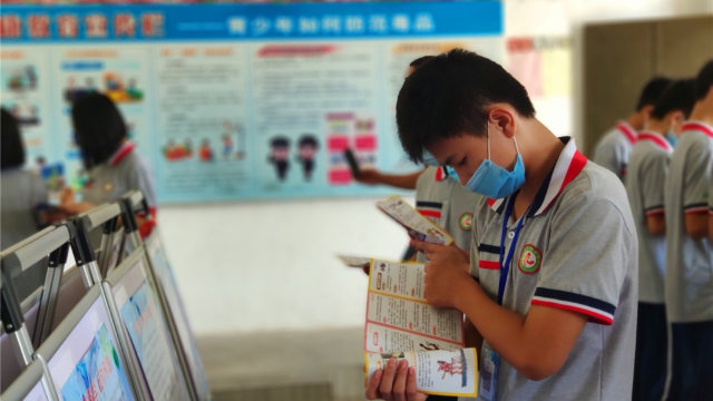 A student reads anti-xie jiao materials on a school campus in Guangdong’s Enping city in June.