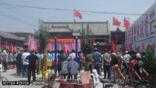 People gathered outside the Huaguanying village’s Mao Zedong memorial hall on July 1. The sign on the wall reads: “Mao Zedong Thought will brightly shine forever.” 
