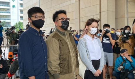 Hong Kong activists, from left, Joshua Wong, Ivan Lam and Agnes Chow arrive at a court in Hong Kong,